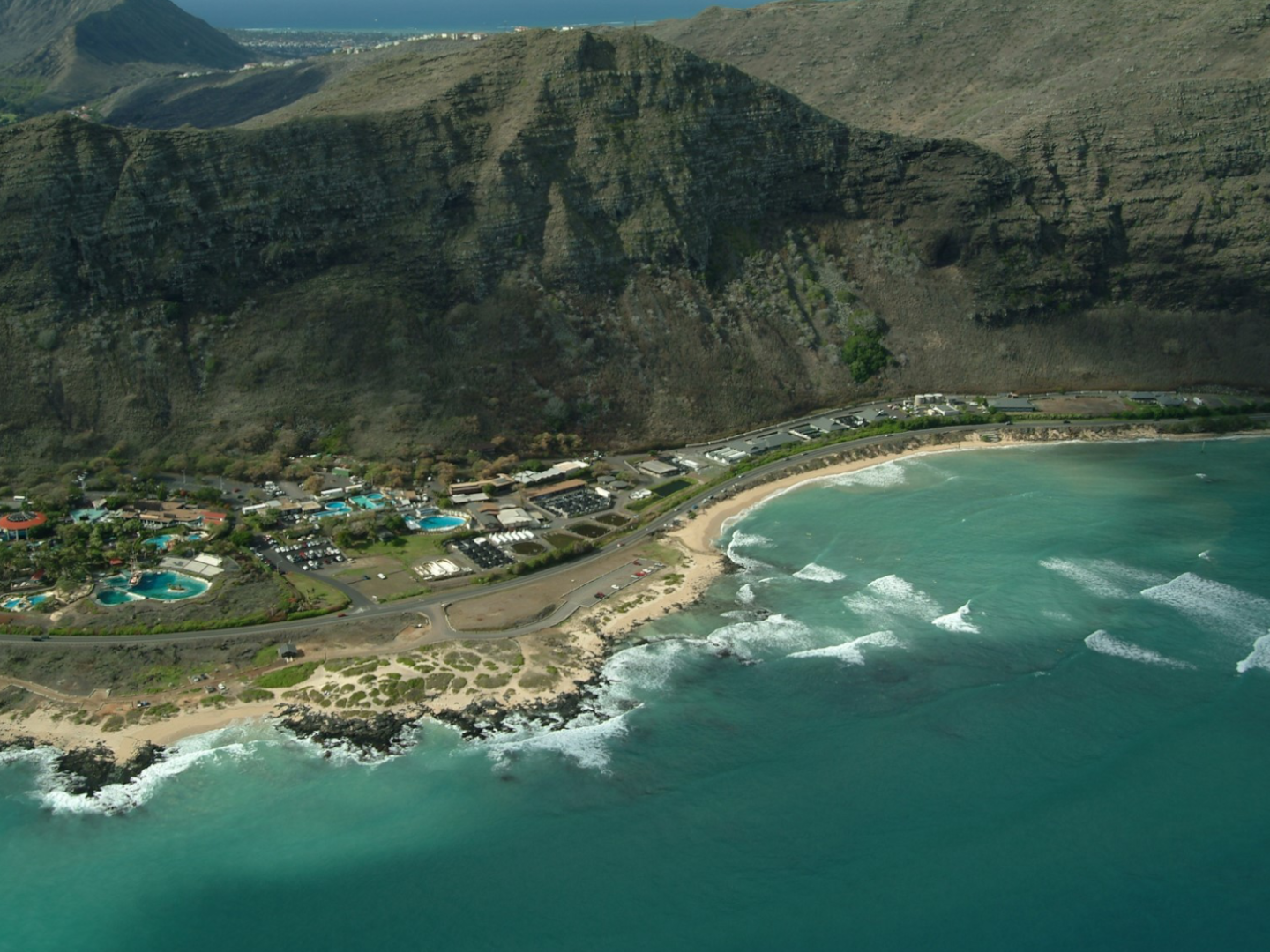 Two large ships with cranes transporting super sacks of derelict fishing gear to shipping containers. Aerial video of HPU's Makapu'u Campus. A pile of fishing net, line, and floats.